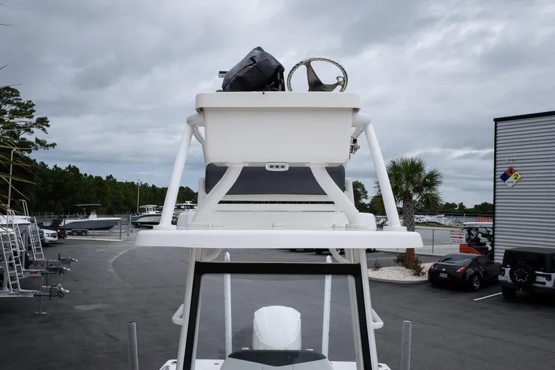 Slide: The Image of 2019 Robalo 246 Cayman SD boat with elevated helm station, parked outdoors under cloudy skies. - 34