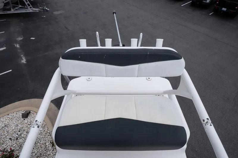 Slide: The Image of 2019 Robalo 246 Cayman SD boat seating area, featuring white and black cushioned seats. - 36