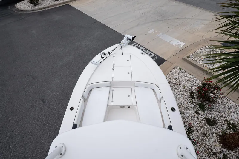 Slide: The Image of 2019 Robalo 246 Cayman SD boat bow view, parked on concrete with landscaping. - 39