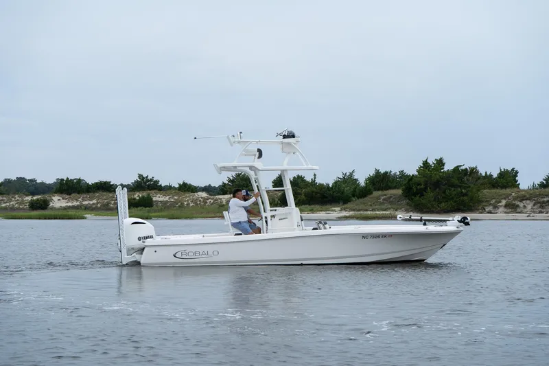 Slide: The Image of 2019 Robalo 246 Cayman SD boat cruising on a calm waterway. - 7