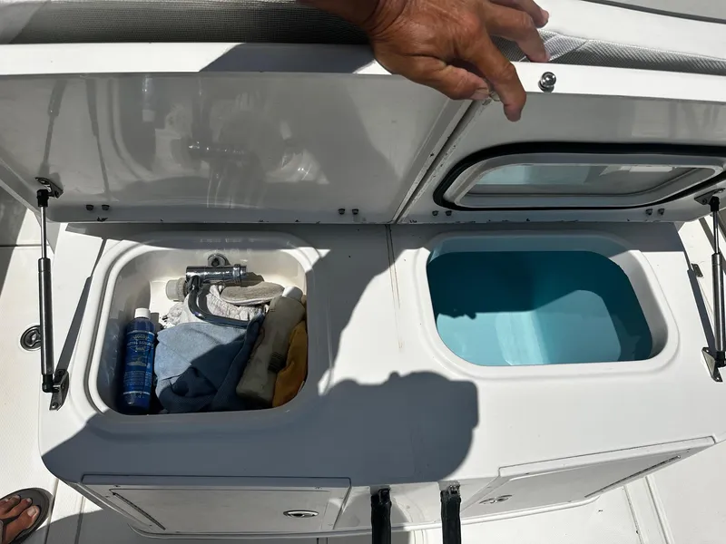Slide: The Image of 2007 Robalo R300 Center Console storage compartments with cleaning supplies and water. - 17