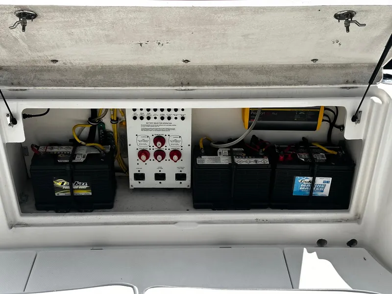 Slide: The Image of Battery compartment of 2007 Robalo R300 Center Console with multiple marine batteries and control panel. - 19