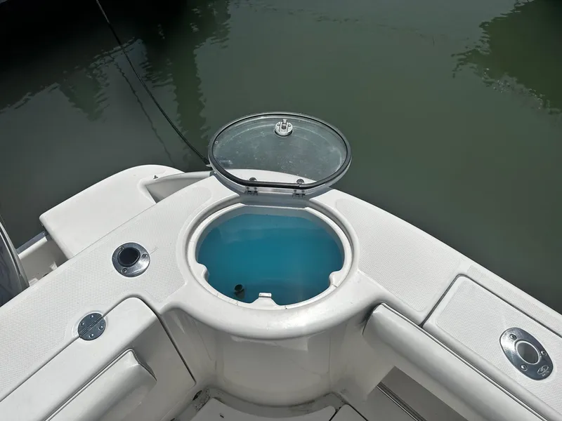 Slide: The Image of 2007 Robalo R300 Center Console boat with open livewell, docked on calm water. - 20