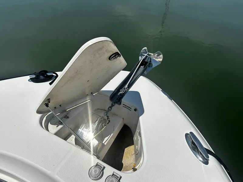 Slide: The Image of 2007 Robalo R300 Center Console boat anchor compartment open on calm water. - 4