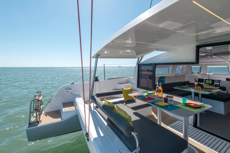 Slide: The Image of Modern NEEL 43 trimaran with spacious deck and dining area, sailing on open sea, 2025 model. - 19