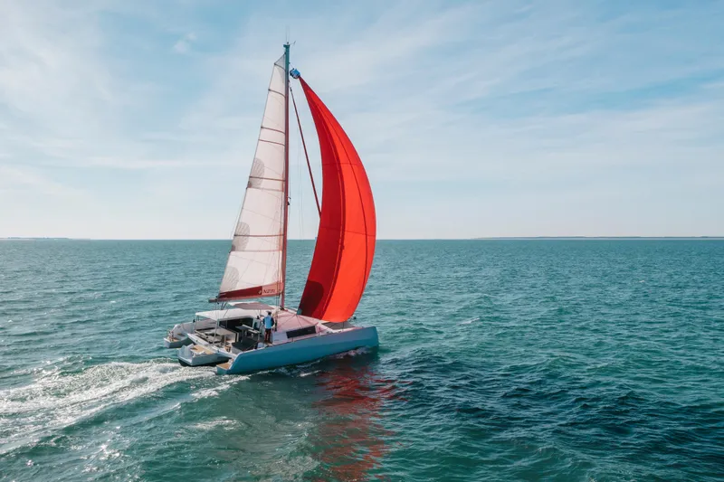 Slide: The Image of Sailing trimaran NEEL 43, 2025 model, with red sail on open sea. - 22