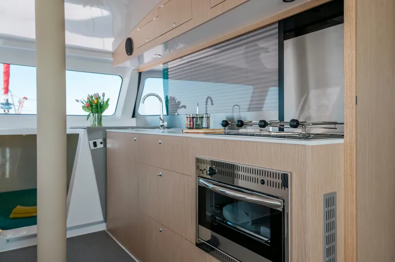 Slide: The Image of Modern kitchen interior of NEEL 43 yacht, featuring sleek appliances and wooden cabinetry, 2025 model. - 32