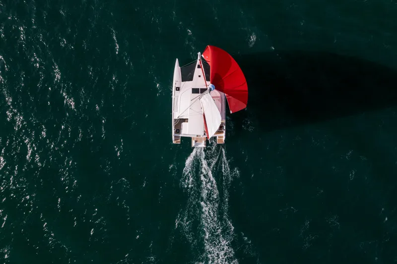 Slide: The Image of Aerial view of NEEL 43 trimaran sailing with red sail on open water, 2025 model. - 40