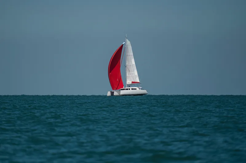 Slide: The Image of Sailing yacht NEEL 43 with red sail on open sea, 2025 model. - 46