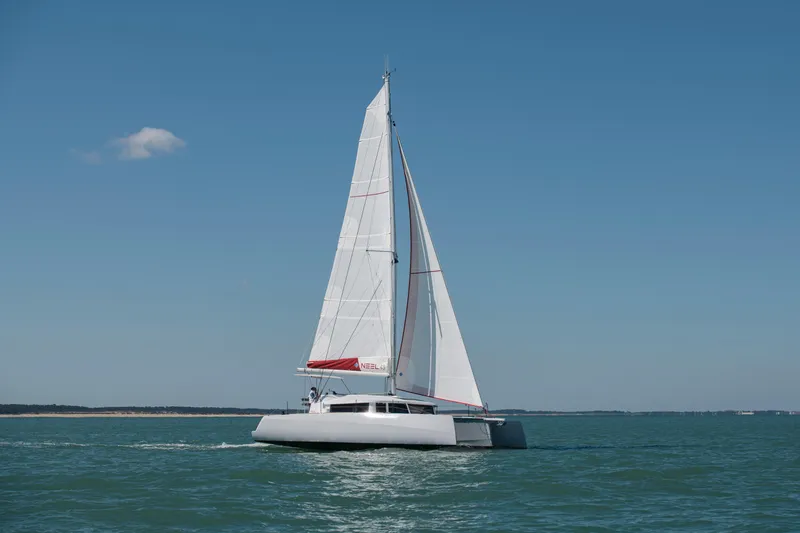 Slide: The Image of Sailing trimaran NEEL 43, 2025 model, gliding on open sea under clear blue sky. - 47