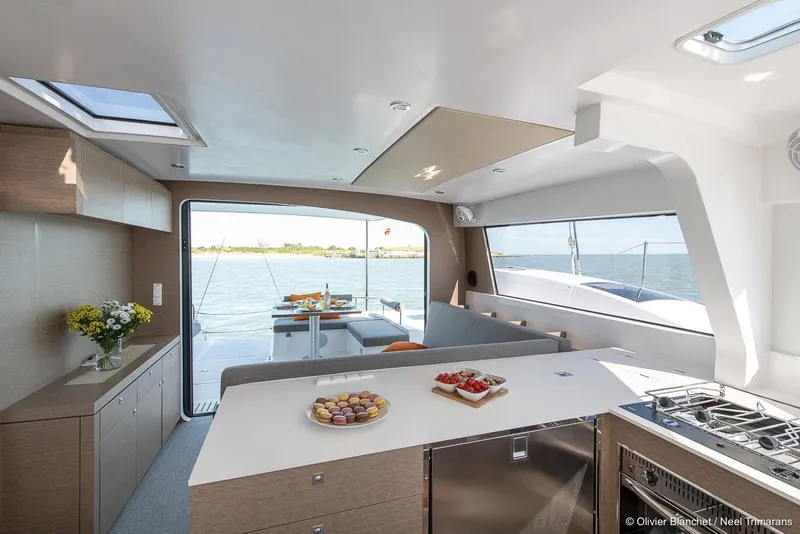 Slide: The Image of Modern NEEL 47 yacht interior with kitchen and dining area, overlooking the ocean, 2025 model. - 10