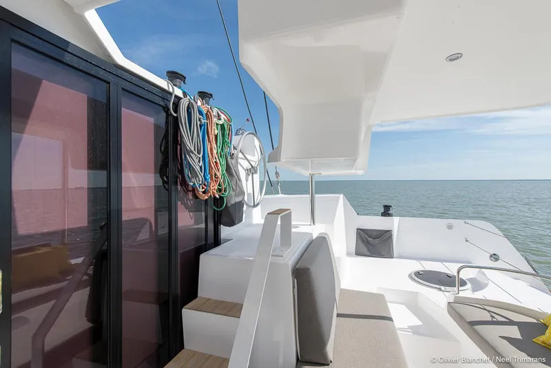 Slide: The Image of Modern NEEL 47 trimaran deck with seating, ropes, and ocean view, 2025 model. - 16