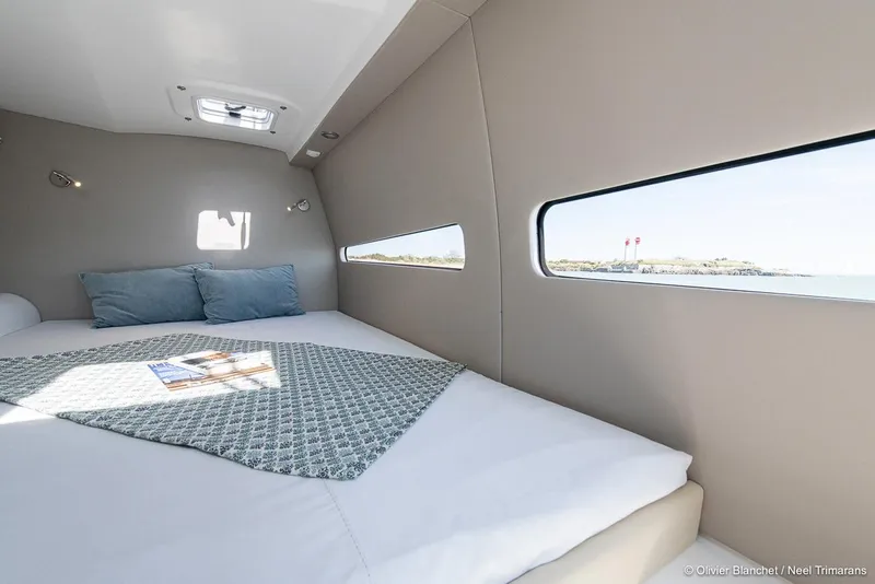 Slide: The Image of Luxurious cabin interior of NEEL 47 trimaran, 2025 model, featuring a comfortable bed and scenic window view. - 19