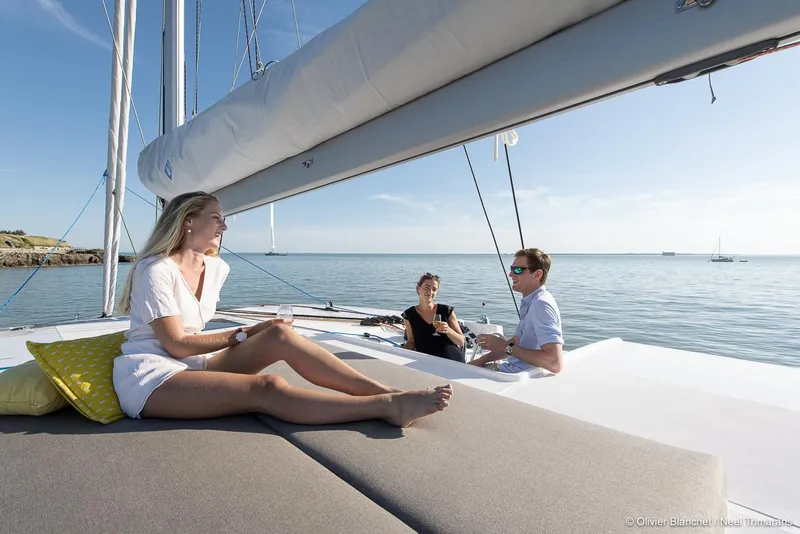Slide: The Image of People relaxing on a NEEL 47 trimaran yacht, 2025 model, enjoying a sunny day at sea. - 20