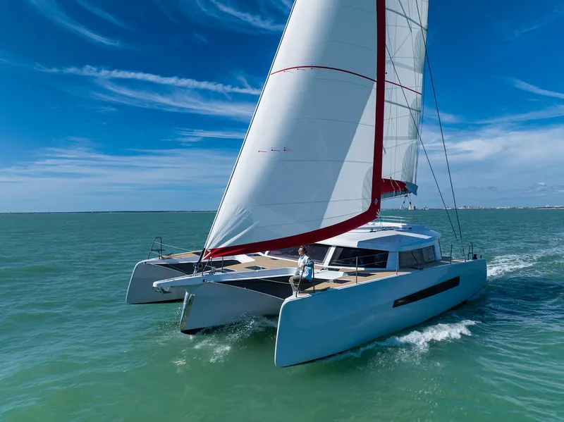 Slide: The Image of Sailing NEEL 52 trimaran on open sea, 2025 model, under clear blue sky. - 4