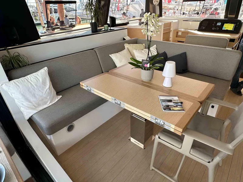 Slide: The Image of Modern NEEL 52 yacht interior with cozy seating, table, and decor, 2025 model. - 12