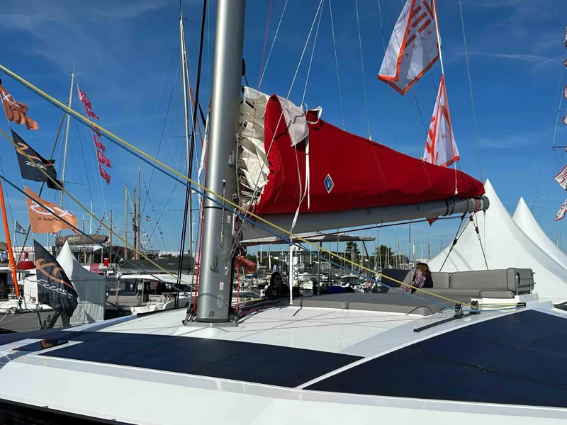 Slide: The Image of Sleek NEEL 52 trimaran with red sail, docked at marina, 2025 model. - 3