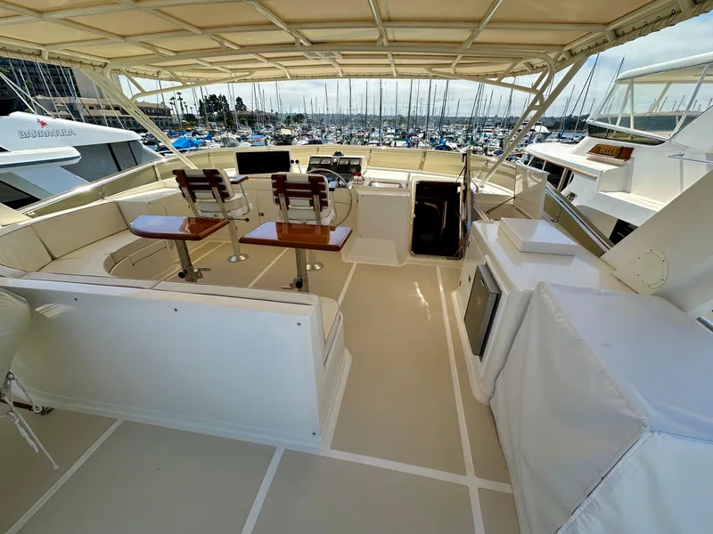 Slide: The Image of Pilothouse yacht interior with helm, seating, and marina view. Offshore Yachts, 2000 model. - 17