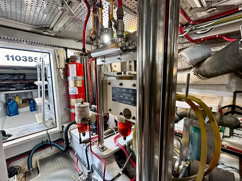 Slide: The Image of Engine room of 2000 Offshore Yachts Pilothouse, featuring complex machinery and fire safety equipment. - 22