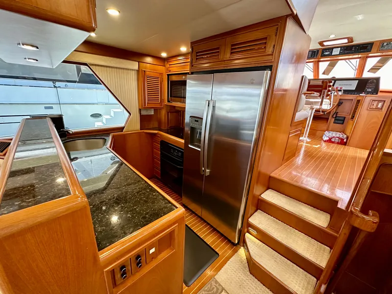 Slide: The Image of Luxurious 2000 Offshore Yachts Pilothouse kitchen with stainless steel appliances and wood cabinetry. - 8