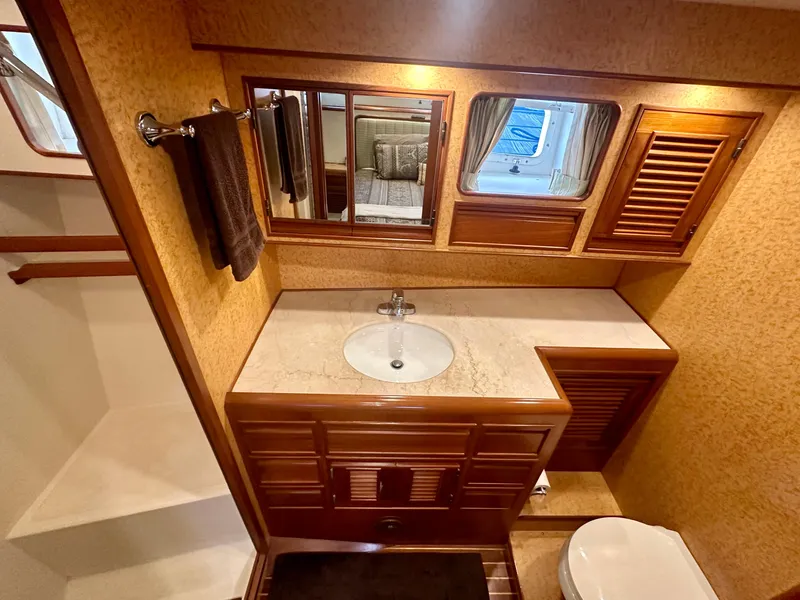 Slide: The Image of Luxurious bathroom in a 2000 Offshore Yachts Pilothouse, featuring wood accents and elegant fixtures. - 13