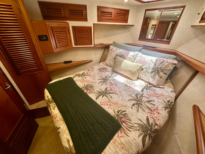 Slide: The Image of Cozy bedroom in 2000 Offshore Yachts Pilothouse with tropical bedding and wooden accents. - 14