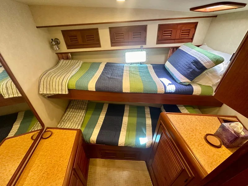 Slide: The Image of 2000 Offshore Yachts Pilothouse cabin with bunk beds and colorful bedding. - 16