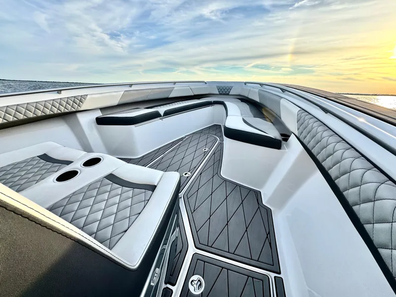 Slide: The Image of Luxurious 2019 Statement 350 Open boat interior with quilted seating and ocean view at sunset. - 12
