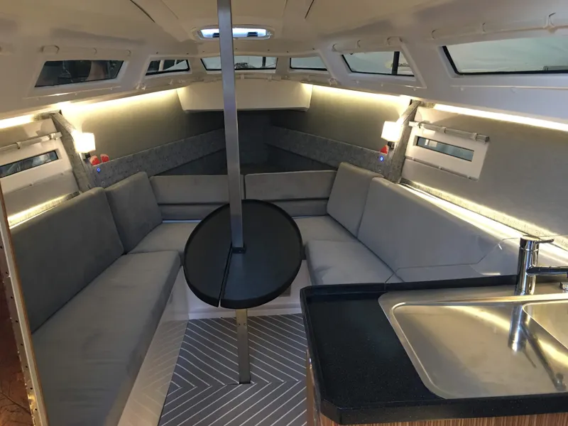 Slide: The Image of Luxurious interior of 2025 Faro Yachts 29, featuring modern seating and sleek kitchen area. - 14
