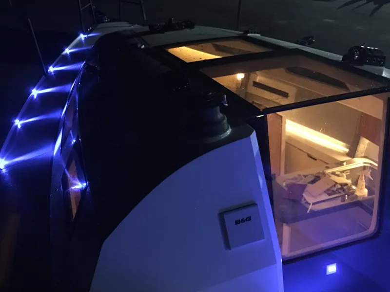 Slide: The Image of 2025 Faro Yachts 29 with illuminated deck and modern interior at night. - 27