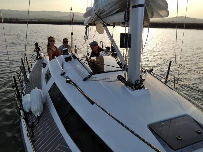 Slide: The Image of 2025 Faro Yachts 29 sailing with passengers on a serene waterway at sunset. - 3