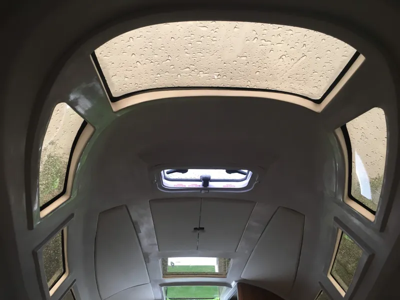 Slide: The Image of Interior view of 2025 Faro Yachts 29 cabin with raindrop-covered windows. - 30