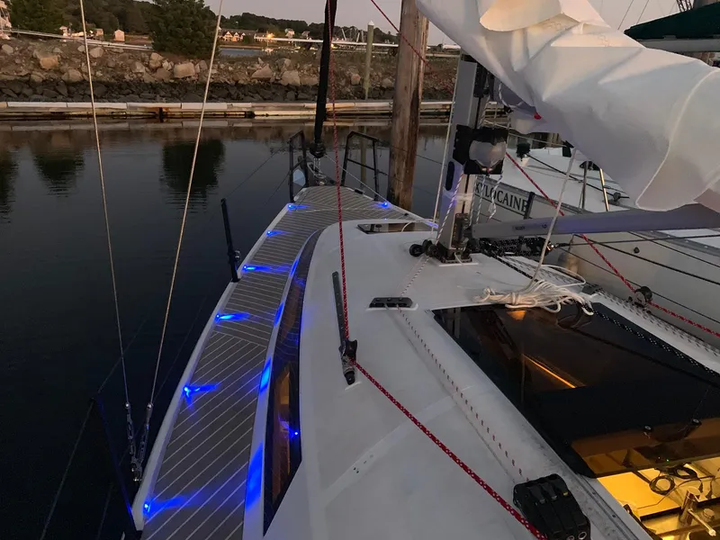 Slide: The Image of 2025 Faro Yachts 29 sailboat with blue deck lights docked at sunset. - 35