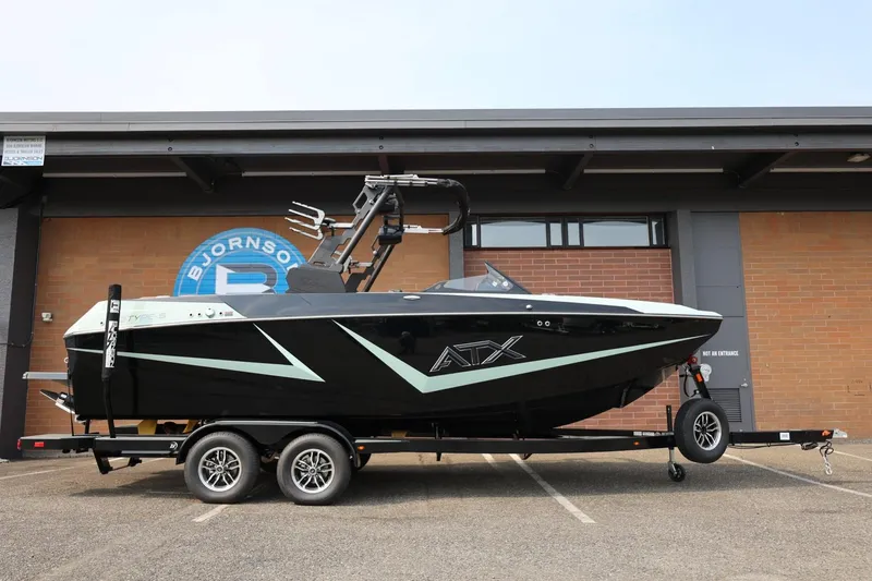 Slide: The Image of 2026 ATX Surf Boats 22 Type-S on trailer, parked outside a building. - 2