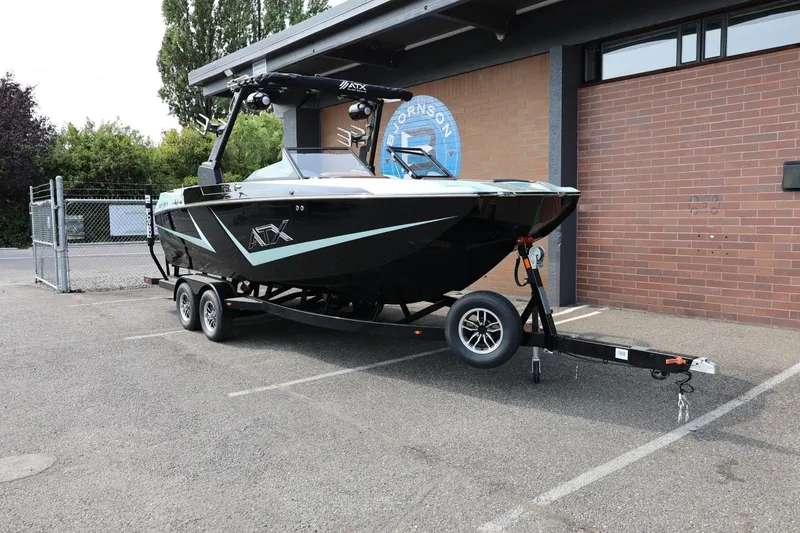 Slide: The Image of 2026 ATX Surf Boats 22 Type-S on trailer, parked outdoors near a brick building. - 3