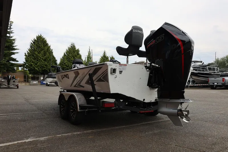 Slide: The Image of 2026 Lund 2075 Pro-V Bass XS boat with powerful outboard motor in a parking lot. - 10