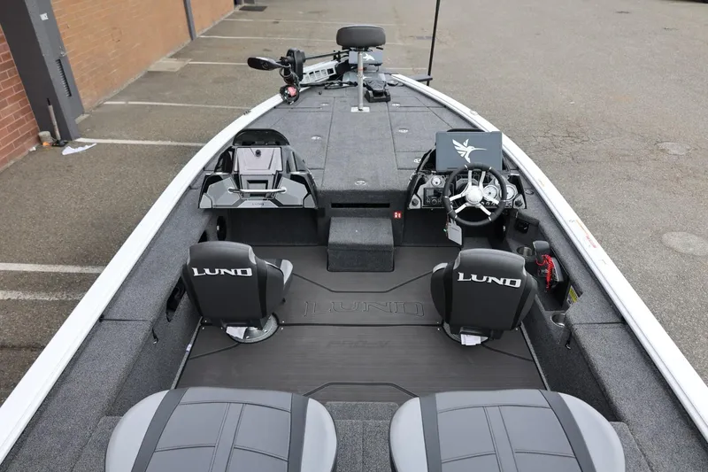 Slide: The Image of 2026 Lund 2075 Pro-V Bass XS boat interior with steering wheel and seating. - 13