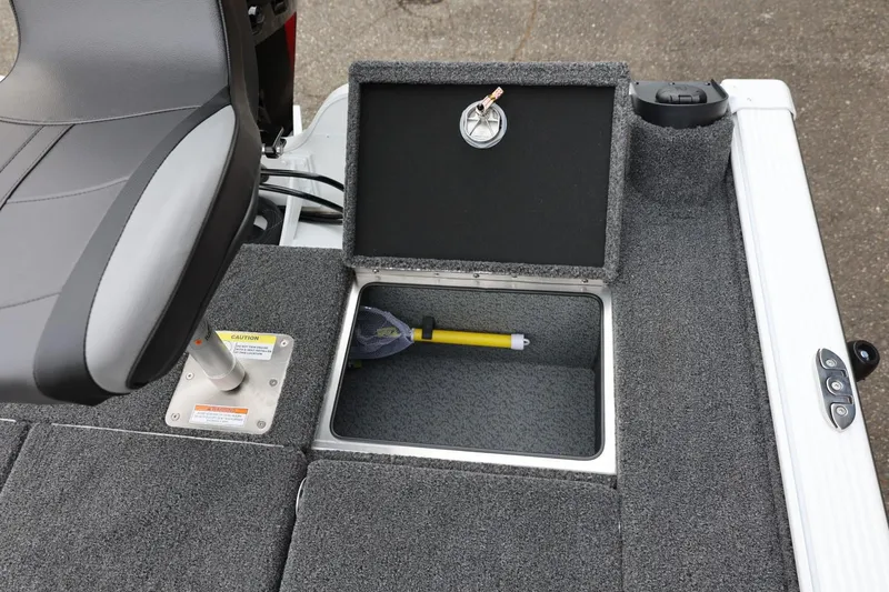 Slide: The Image of 2026 Lund 2075 Pro-V Bass XS boat storage compartment with seat and carpeted interior. - 19