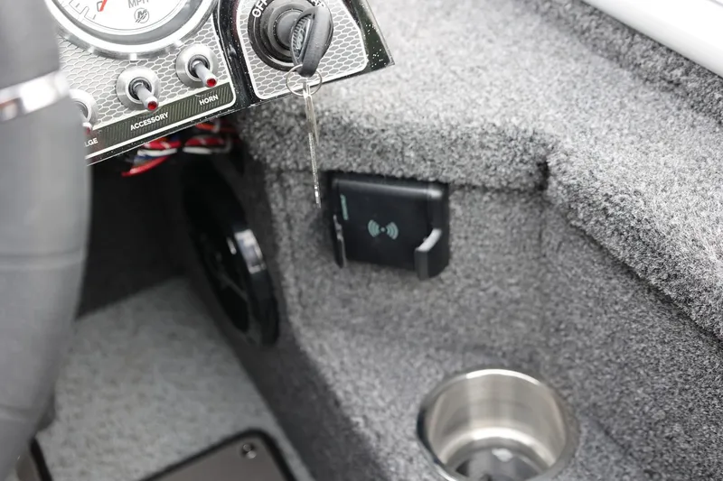 Slide: The Image of 2026 Lund 2075 Pro-V Bass XS dashboard with ignition key and cup holder. - 27