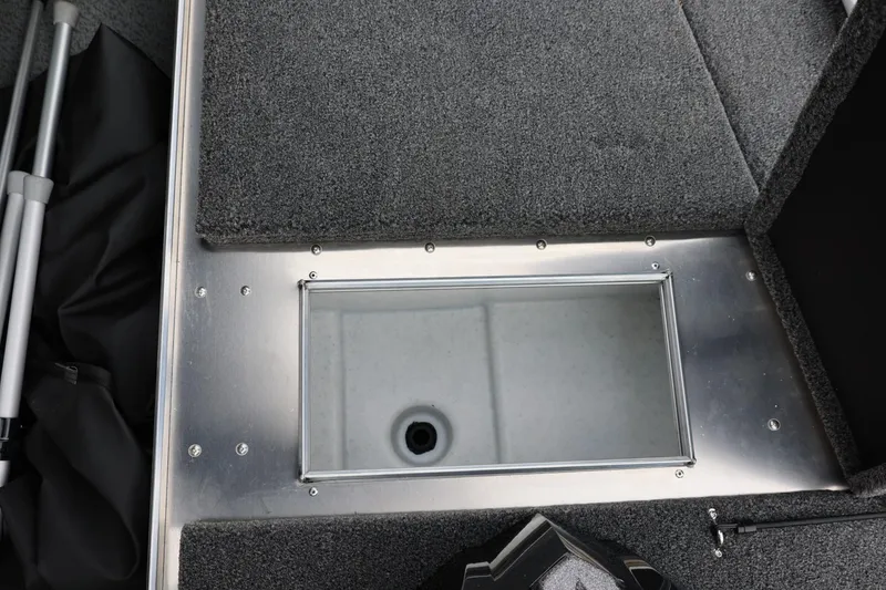 Slide: The Image of 2026 Lund 2075 Pro-V Bass XS boat storage compartment with gray carpeted interior. - 36