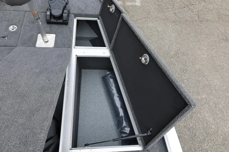 Slide: The Image of 2026 Lund 2075 Pro-V Bass XS boat storage compartments with gray carpeted interior. - 37