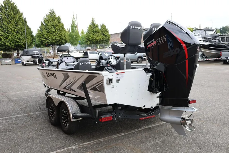 Slide: The Image of 2026 Lund 2075 Pro-V Bass XS boat with Mercury Pro XS engine in a parking lot. - 9