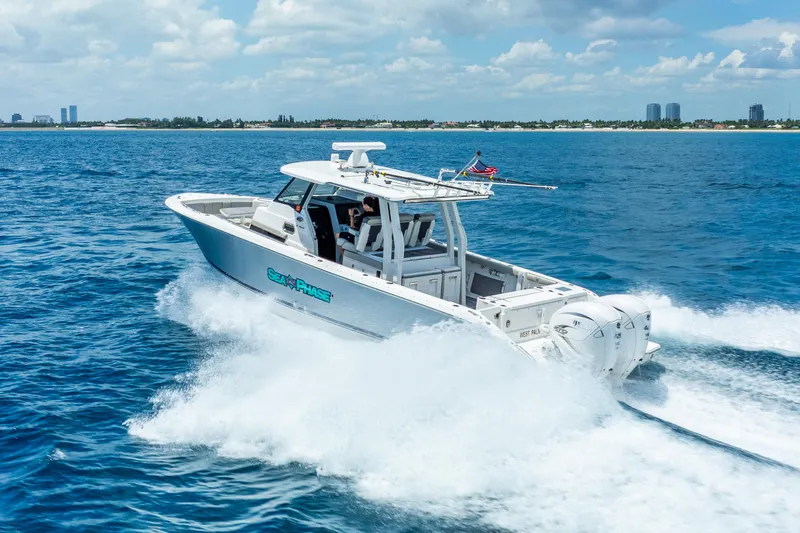 Slide: The Image of 2024 Pursuit S 358 Sport boat cruising on open water under a clear sky. - 0
