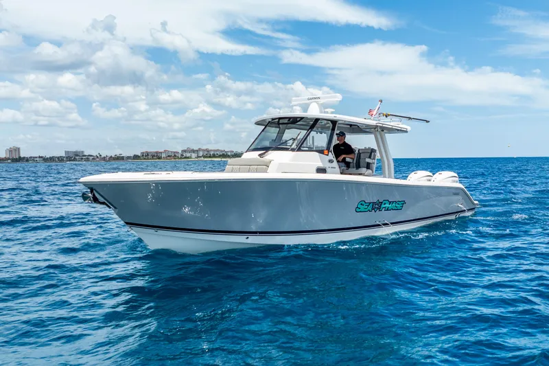 Slide: The Image of 2024 Pursuit S 358 Sport boat cruising on open water under a clear sky. - 10