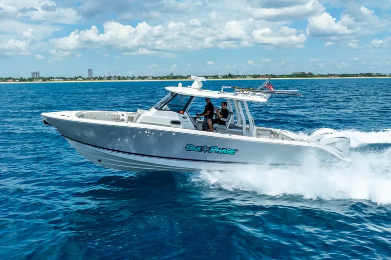 Slide: The Image of 2024 Pursuit S 358 Sport boat cruising on open blue water under a cloudy sky. - 14