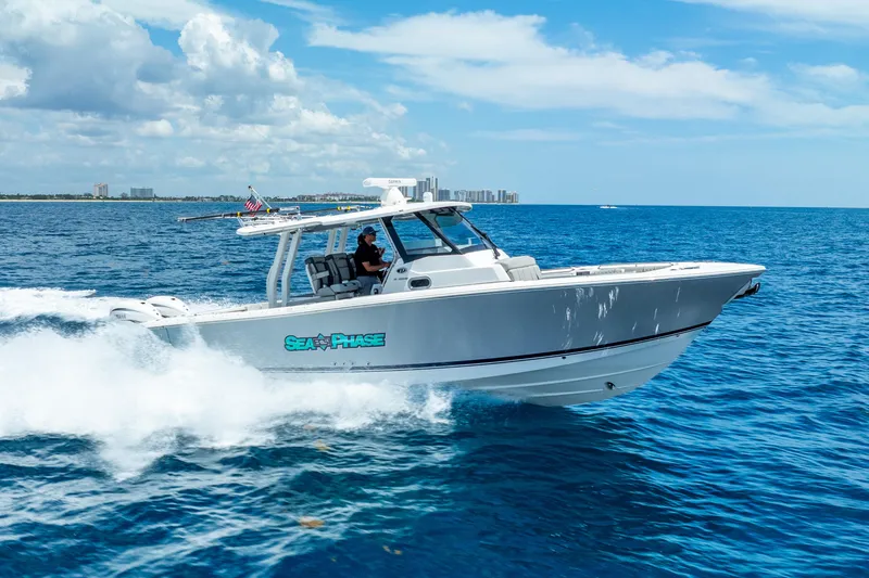 Slide: The Image of 2024 Pursuit S 358 Sport boat cruising on open ocean under clear blue sky. - 18