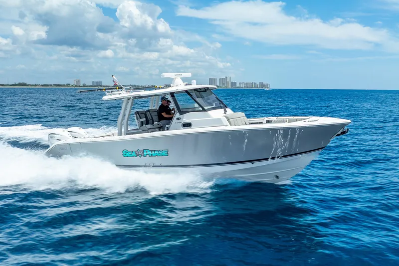 Slide: The Image of 2024 Pursuit S 358 Sport boat cruising on open blue ocean under clear sky. - 19