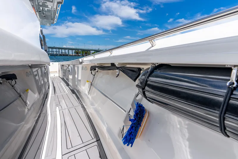 Slide: The Image of 2024 Pursuit S 358 Sport boat deck with storage compartments and clear blue sky. - 26