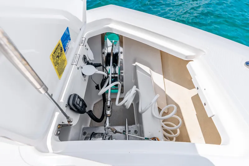Slide: The Image of 2024 Pursuit S 358 Sport boat anchor compartment with coiled rope and control panel. - 27