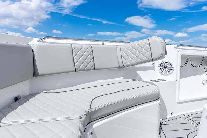 Slide: The Image of 2024 Pursuit S 358 Sport boat interior with luxurious seating and speaker, under a clear blue sky. - 30